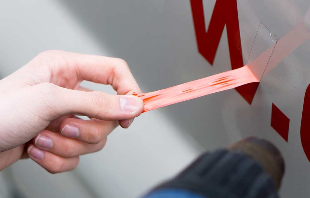 Dezente Beschriftung wird an Fahrzeug angebracht.