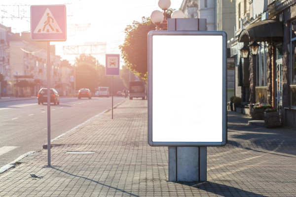 Leuchtrahmen Werbung an einer sonnigen Straßenpromenade mit leerer Werbefläche neben der Fahrbahn